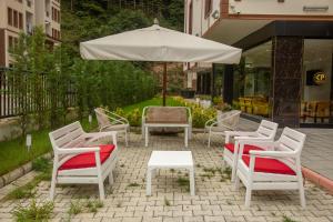 a group of chairs and an umbrella on a patio at ÇAYKARA PARK HOTEL in Çaykara