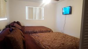 a bedroom with two beds and a flat screen tv at The Jazzy Escape in Miami