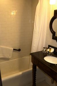 bagno con lavandino, vasca e lavandino di The Holland Hotel ad Alpine