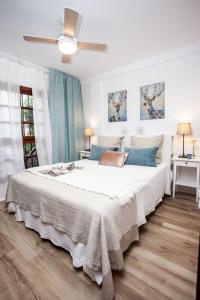 um quarto com uma grande cama branca com almofadas azuis em Spectacular Ocean Apartment with AirCon in Golden Mile of Las Americas em Arona