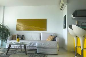 a living room with a white couch and a table at Morros Suites Apartamentos in Cartagena de Indias