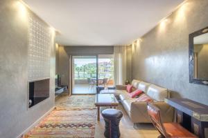 a living room with a couch and a fireplace at Coin Lumineux à Prestigia Piscine - vue Atlas in Marrakech