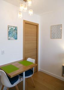 a dining room with a wooden table and chairs at Beausoleil Studio Metro Paris Sud in Le Kremlin-Bic&ecirc;tre