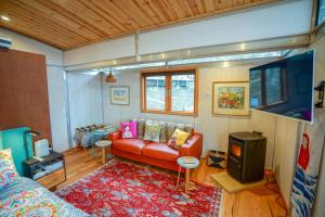 a living room with a red couch and a tv at Free Spirit Pods in Barnes Bay