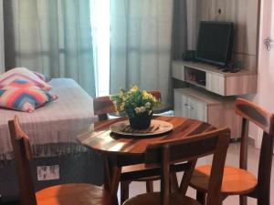 Habitación pequeña con mesa con sillas y cama en VG Fun Residence Praia do Futuro, en Fortaleza