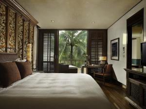 a bedroom with a bed and a window and a desk at Four Seasons Resort Bali at Sayan in Ubud +37 photos