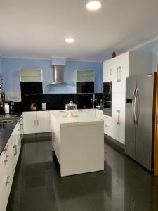 a kitchen with white cabinets and stainless steel appliances at The Right Place to Relax in Santo António