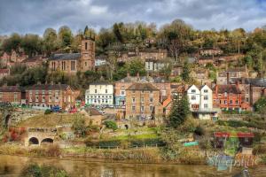a town on a hill next to a river at IRONBRIDGE - 18th CENTURY THREE BEDROOM COTTAGE - 6 BEDS in Ironbridge
