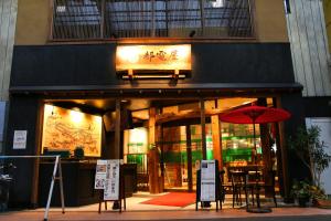 a restaurant with a red umbrella in front of it at 都電屋 TodenHotel in Tokyo