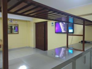 Habitación con 2 monitores en la pared en Hostal Inversiones Huachipa, en Lima