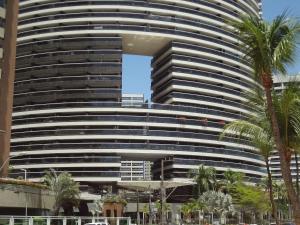 a large building with palm trees in front of it at Landscape Beira-Mar Perfect in Fortaleza