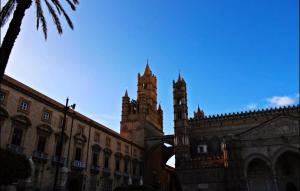 um edifício com uma torre de relógio ao fundo em Dietro la Cattedrale em Palermo