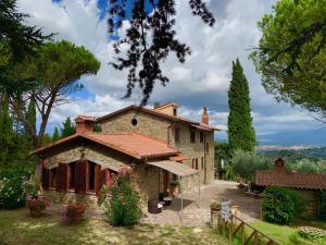 una grande casa in pietra con un giardino di fronte di Casa di Sasso ad Arezzo