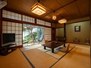 a living room with a table and a tv at Iwamotoro in Fujisawa