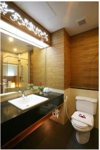a bathroom with a sink and a toilet and a mirror at Baan Saikao Plaza Hotel & Service Apartment in Ko Chang