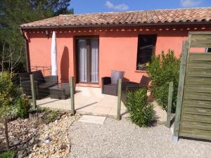 a small house with chairs and a patio at Gîte Les Esparrus in Villecroze