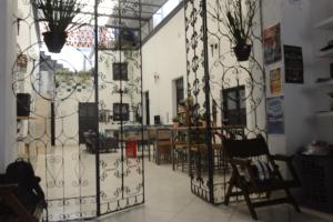 a room with a gate with chairs and tables at El Petate Hostel in Querétaro