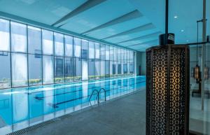 uma grande piscina num edifício com janelas de vidro em CITIC Pacific Zhujiajiao Jin Jiang Hotel em Qingpu