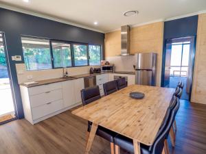a kitchen and dining room with a wooden table and chairs at Tanah Marah in Margaret River Town +33 photos