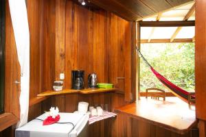 a room with a hammock and a room with a window at Bungalows Aché Cahuita in Cahuita +196 photos