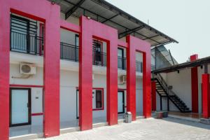 um edifício com colunas vermelhas à sua frente em RedDoorz Syariah near Alun Alun Tegal em Tegal