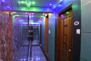 a hallway with purple and green lights in a building at Gayathri Stay in Kanchipuram +10 photos