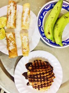 Golden Forest Homestay في فونغ نها: طاولة مع أطباق من الطعام ووافل وموز