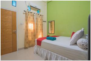 a bedroom with a bed and a window at RedDoorz near Lapangan Tenis Balikpapan in Balikpapan