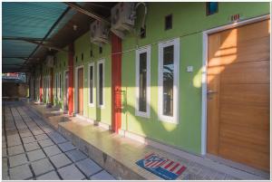 a hallway of a building with green and colorful walls at RedDoorz near Lapangan Tenis Balikpapan in Balikpapan