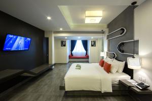 a hotel room with a bed and a flat screen tv at Central Suite Residence in Siem Reap