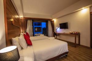 a hotel room with a bed and a television at SugarCane Chiang Mai in Chiang Mai
