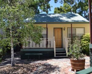 a small yellow house with a porch and stairs at Avoca Cottages VICTORIA in Avoca
