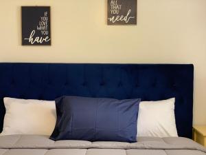 a blue headboard of a bed with two pillows at The Palace at Kingston East in Rexburg