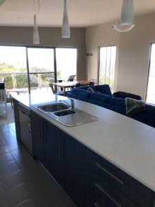 a kitchen with a sink and a living room at Bicheno Views on Douglas in Bicheno