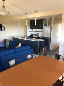 ein Wohnzimmer mit einem blauen Sofa und einem Tisch in der Unterkunft Bicheno Views on Douglas in Bicheno