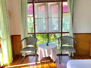 a room with a table and two chairs and a window at Mali House in Mae Nam