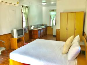 una camera con un grande letto bianco e una TV di Mali House a Mae Nam
