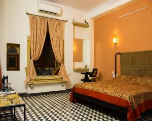 a hotel room with a bed and a window at Jaisal Castle Homestay in Jaipur