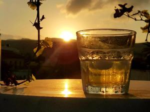 un vaso de agua sentado en una mesa con la puesta de sol en Hostel Stylianos Kissamos, en Kissamos