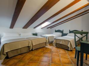 a bedroom with three beds in a room with a ceiling at Hotel Jaime I in Mora de Rubielos