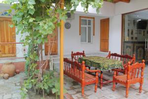eine Terrasse mit einem Tisch und Bänken in einem Haus in der Unterkunft Samani Bukhara in Buxoro