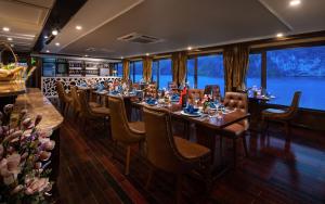 a restaurant with tables and chairs and a large window at La Pandora Cruises in Ha Long