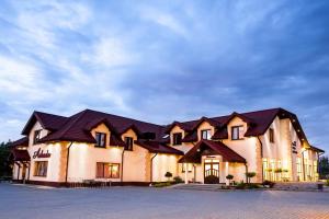 a large building with black roof at Hotel Arkada in Rawa Mazowiecka