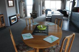 una mesa de comedor de madera con un tazón verde. en The Mackenzie Apartments en Lake Tekapo