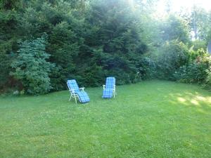 due sedie blu sedute nell'erba in un giardino di Bergblick a Siedelsbrunn