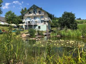 una grande casa con un laghetto di fronte di Narnhoferwirt a Sankt Jakob im Walde