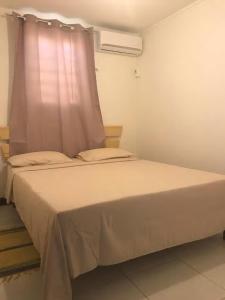 1 dormitorio con 1 cama blanca y ventana en LeSaintCyr, en Sainte-Rose