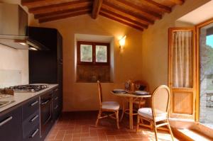 a kitchen with a table and chairs in a kitchen at Agriturismo Montecchio in Semproniano