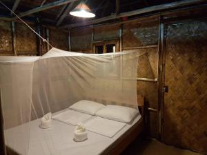 a tent with two white pillows on a bed at CXJ Travelers Inn in San Vicente