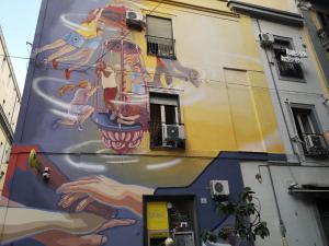a large mural on the side of a building at Grande Archivio Napoli 22 in Naples